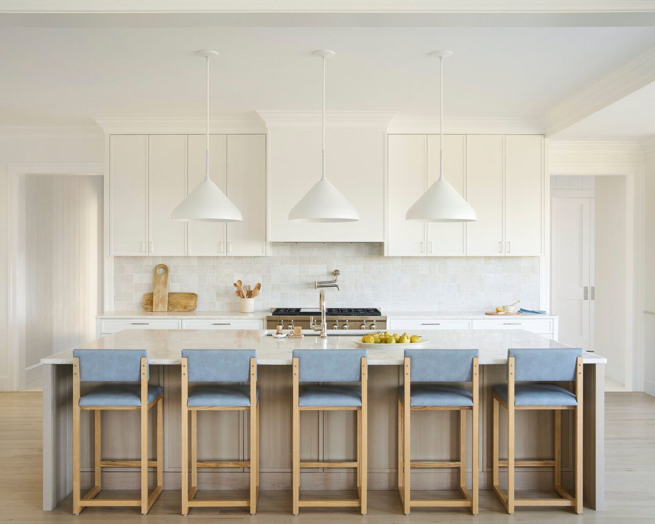 A trio of Pelle's Stem Shade 20 Pendants in white powder coat hang above a kitchen island.