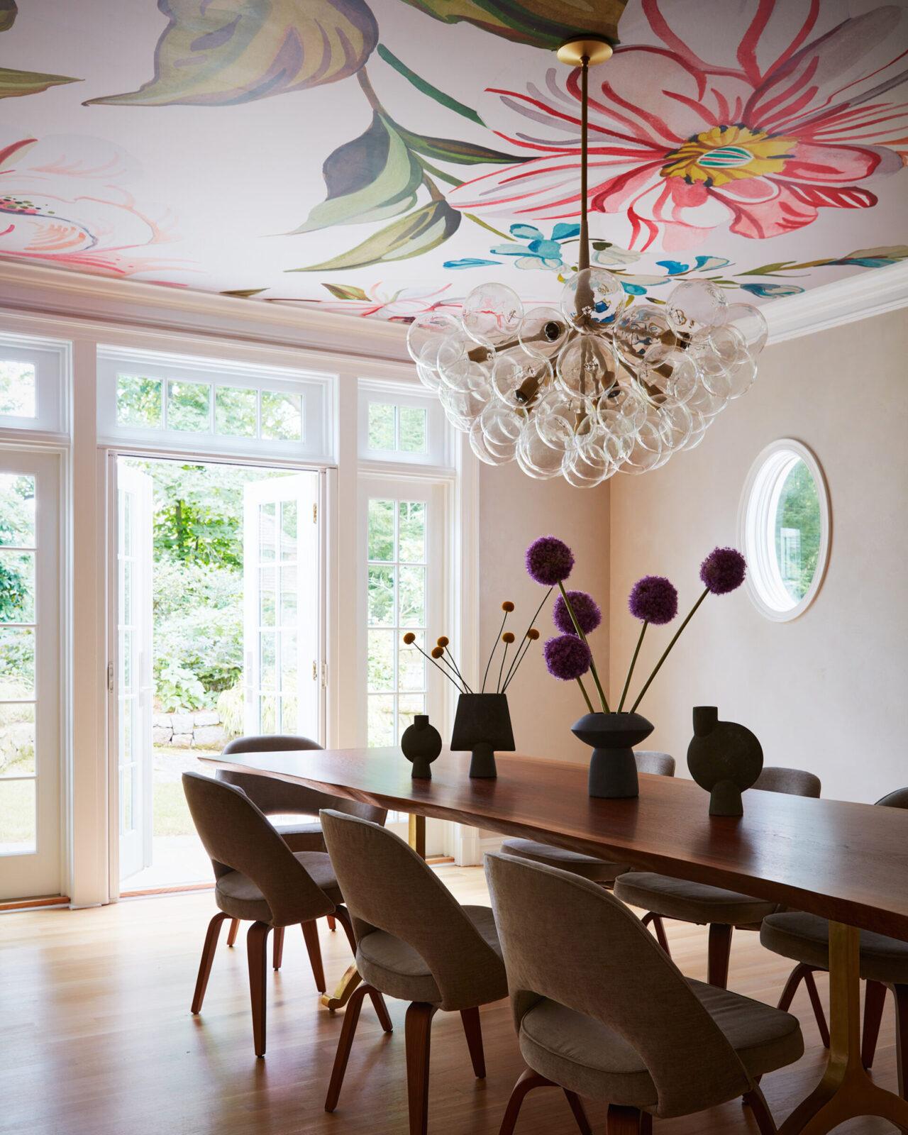 Pelle's Supra Bubble Chandelier installed in a colorful dining room with floral wallpapered ceiling.
